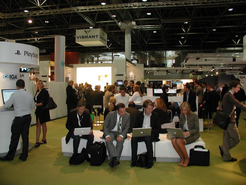 Reisende mit Laptops auf einer Technikmesse