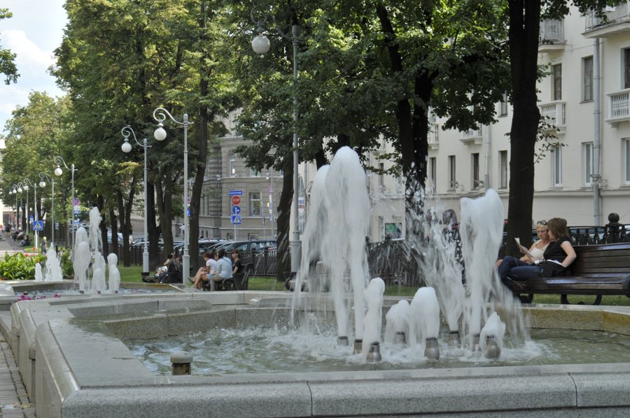 Fountains and benches beneath trees in a public space in Minsk